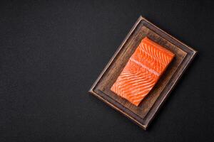 Fresh raw salmon steak with spices and herbs prepared for grilled baking photo