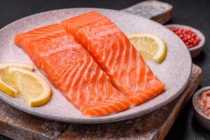 Fresh raw salmon steak with spices and herbs prepared for grilled baking photo