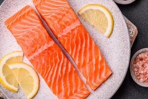 Fresh raw salmon steak with spices and herbs prepared for grilled baking photo