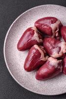 Raw turkey or chicken hearts with salt and spices photo