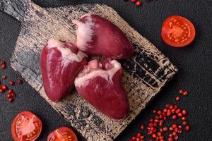 Raw turkey or chicken hearts with salt and spices photo