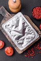 Rectangular plastic box with yogurt or cheese hermetically sealed with a foil lid photo