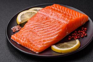 Fresh raw salmon steak with spices and herbs prepared for grilled baking photo