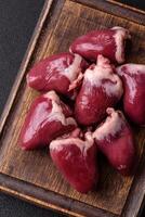 Raw turkey or chicken hearts with salt and spices photo