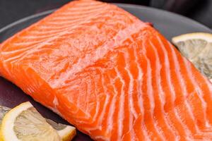 Fresh raw salmon steak with spices and herbs prepared for grilled baking photo