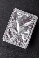 Rectangular plastic box with yogurt or cheese hermetically sealed with a foil lid photo