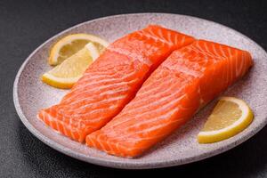 Fresh raw salmon steak with spices and herbs prepared for grilled baking photo