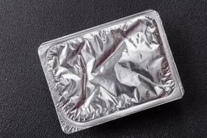 Rectangular plastic box with yogurt or cheese hermetically sealed with a foil lid photo