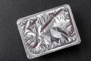 Rectangular plastic box with yogurt or cheese hermetically sealed with a foil lid photo