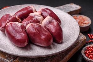 Raw turkey or chicken hearts with salt and spices photo