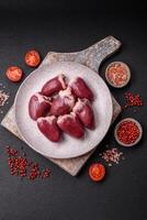 Raw turkey or chicken hearts with salt and spices photo