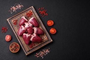 Raw turkey or chicken hearts with salt and spices photo