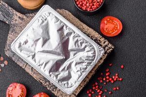 Rectangular plastic box with yogurt or cheese hermetically sealed with a foil lid photo