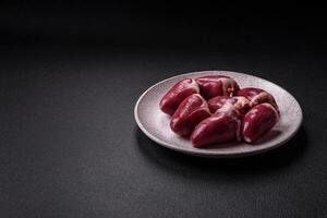 Raw turkey or chicken hearts with salt and spices photo