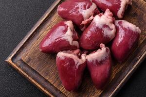 Raw turkey or chicken hearts with salt and spices photo