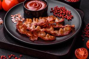 delicioso Fresco frito tocino con sal y especias en un oscuro antecedentes foto