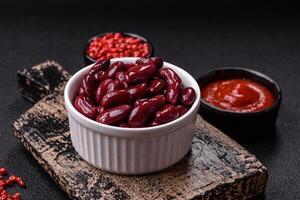 Canned red beans with salt and spices in a white bowl photo
