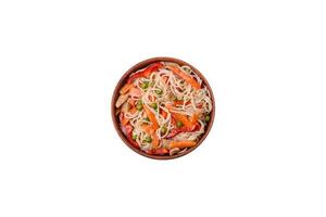 Delicious rice noodles or udon with chicken, carrots, pepper, salt, spices and herbs photo