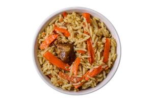 Delicious pilaf with vegetables, salt, spices and herbs in a ceramic plate photo