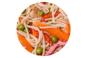 Delicious rice noodles or udon with chicken, carrots, pepper, salt, spices and herbs photo