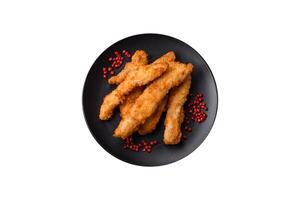 Delicious fresh chicken or turkey strips or nuggets breaded with salt and spices photo