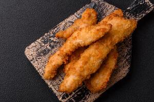 Delicious fresh chicken or turkey strips or nuggets breaded with salt and spices photo