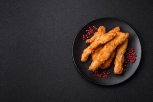 Delicious fresh chicken or turkey strips or nuggets breaded with salt and spices photo