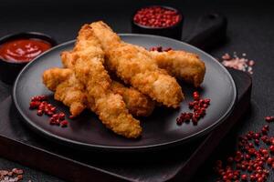 Delicious fresh chicken or turkey strips or nuggets breaded with salt and spices photo