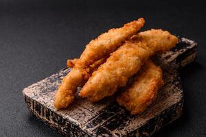 Delicious fresh chicken or turkey strips or nuggets breaded with salt and spices photo