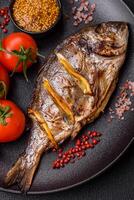 Delicious dorado baked on the grill with salt, spices and herbs photo