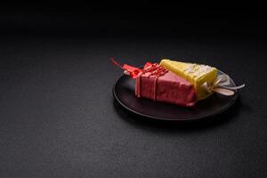 Delicious sweet cheesecake with fruits covered with icing with a wooden stick photo