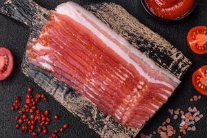 Fresh raw bacon sliced with spices and herbs photo