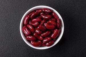 Canned red beans with salt and spices in a white bowl photo