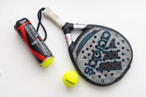 Ukraine Kyiv - March 30, 2024. Padel sport background with racket and ball on white background. Top view. photo