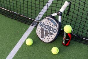 Ukraine Kyiv, 30.03.2024. Padel racket adidas and padel ball on a green court photo