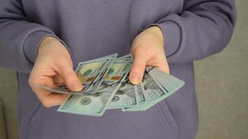 Female hands holding dollars banknotes on a grey background. video