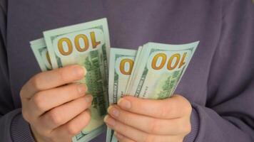 Female hands holding dollars banknotes on a grey background. video