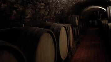 Aged wooden barrels with a wine , brandy or whiskey in a big warehouse. 4K video