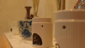 Close-up of ceramic aroma diffusers on a shelf with soft lighting and a blurred background. video