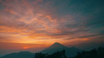 cênico pôr do sol Visão com vibrante céu sobre silhueta do montanha faixa. video