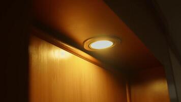 Warm light from a recessed ceiling fixture casting a soft glow on a wooden wall. video