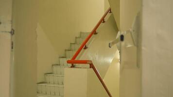 Empty stairwell with orange handrail in a building, depicting urban architecture and design. video