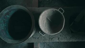 Two rustic metal pots on a weathered wooden surface, with a moody, dark aesthetic. video