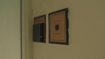 Close-up of a light switch on a beige wall with soft focus background. video