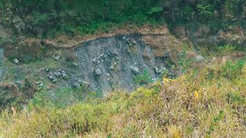 Grassy hillside with exposed rocky soil and sparse vegetation, depicting erosion or natural terrain. video