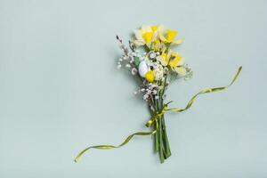 Easter spring bouquet with daffodils and willow on green background. Easter greeting card photo