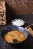 Tom yum soup and rice on a gray background angle view. on dark background photo