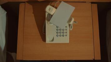 Vintage telephone with notepad and pen on a wooden desk, top view, communication concept. video