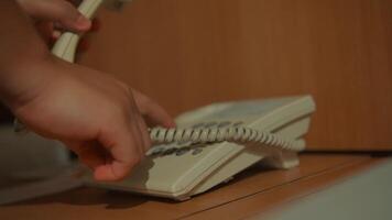 Close-up of a hand hanging up a telephone receiver, with a blurred background, conveying the end of a conversation. video