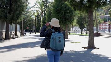 donna passeggiate attraverso il soleggiato strade di barcellona. video